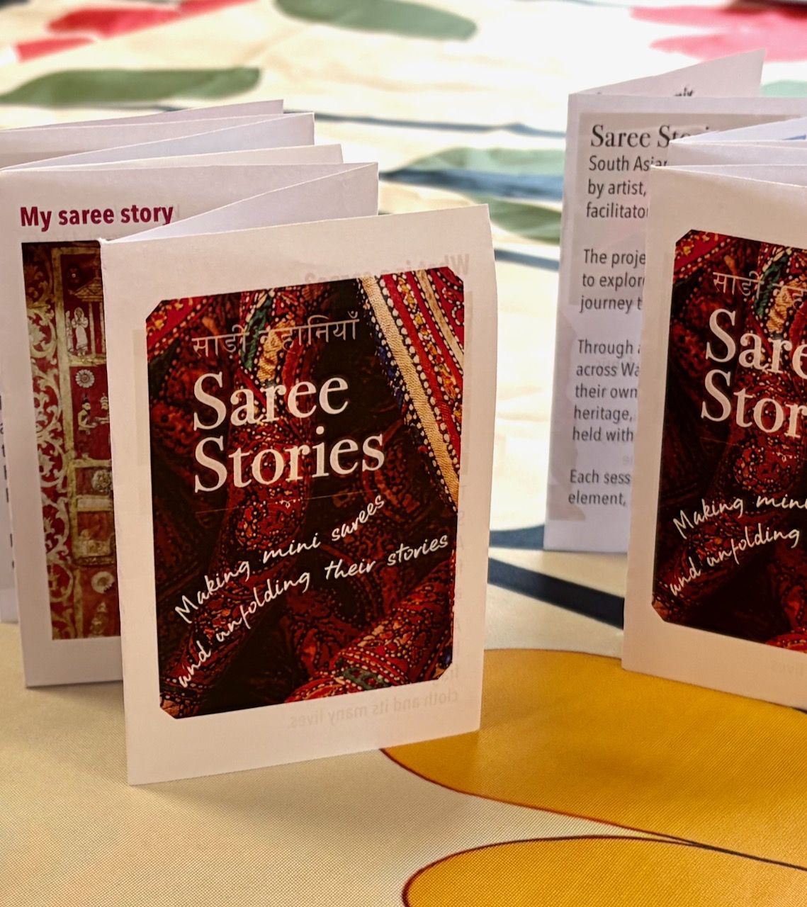 The Saree Stories concertina zine, a small folded booklet of saree facts and fragments made as a visual prompt for the workshops