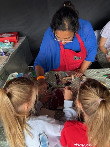 Roopa Basu helping young participants print with leaves at Happy Streets Festival