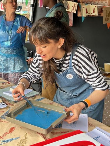A visitor rolling ink for leaf printing at Happy Streets Festival