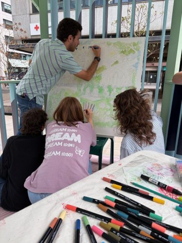 A team colouring the Culture Mile canvas with paint pens