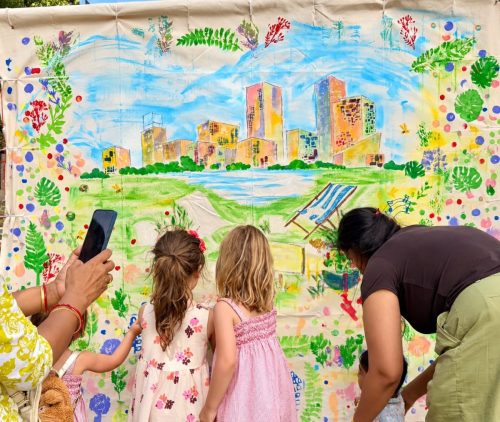 Families and children colouring the East Village giant canvas together
